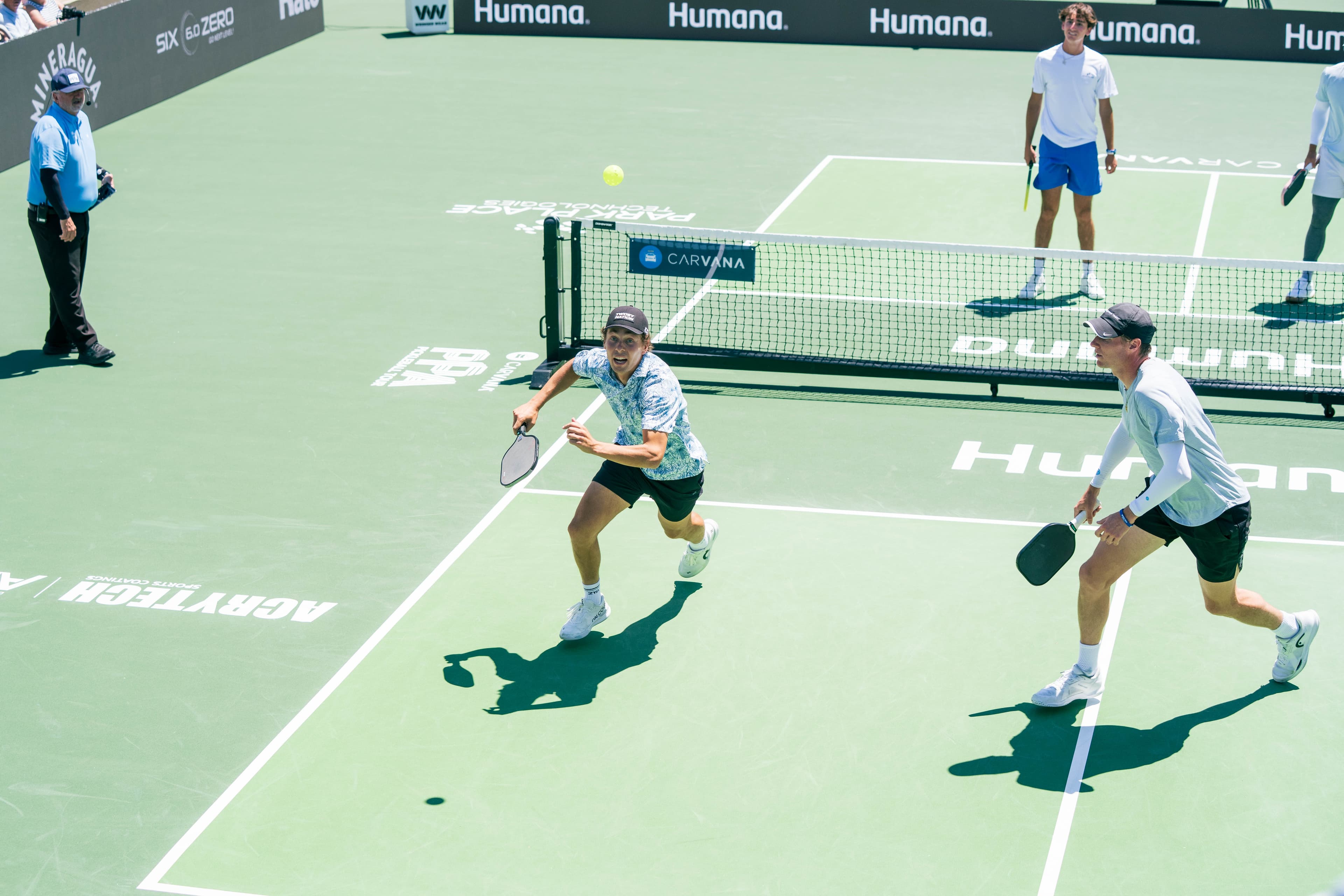 Connor Garnett and his partner attacking an overhead on a pro pickleball court